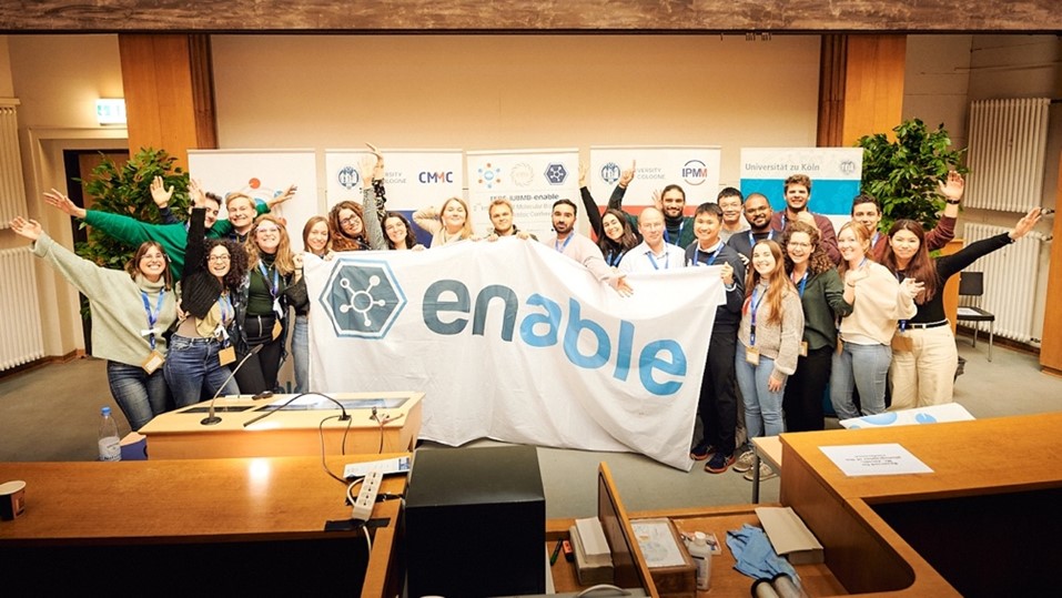 Photo of the FEBS-IUBMB-ENABLE conference organizing committee 2023 holding up the event flag, which is the ENABLE name and logo.